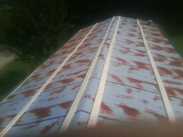 Rusted metal roof panels with new wood purlins before replacement — Storm Damage Roof Repair in Valhermoso Springs by Roofing Brothers