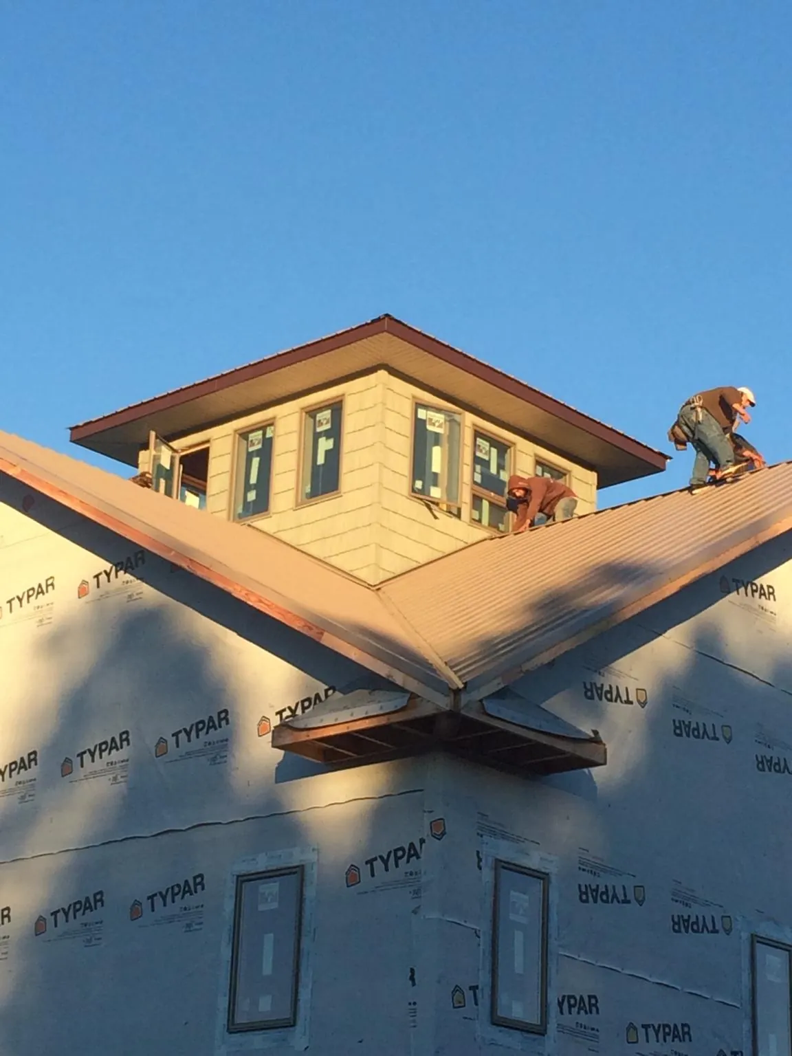 Roofers working around a rooftop cupola on a new metal roof at sunset — Roof Waterproofing in Valhermoso Springs by Roofing Brothers